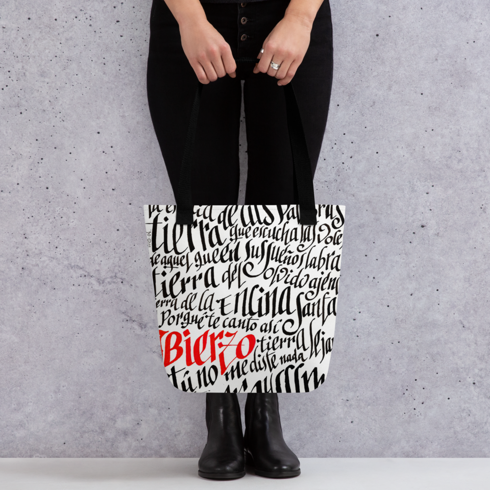 Letra de la canción de Miguel Guerrero : Bierzo tierra lejana. letras caligráficas, negras y palabra Bierzo en rojo, ilustradas en Tote bag blanca con cintas de color negro.