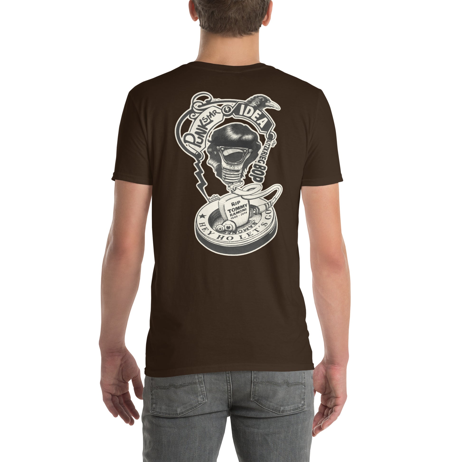 chico con camiseta color marrón de espalda con ilustración de bombilla Tommy Ramone cuervo y las letras punk star idea y hey ho let's go en la espalda